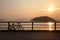 Silhouette of retro bicycle, fence, ocean, mountain at sunset