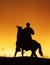 Silhouette of rider on horseback and beautiful orange sunset