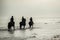 Silhouette of Riders at the beach riding horses