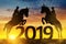 Silhouette the riders on the horse jumping into the New Year 2019.