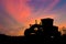 Silhouette of Road grader tractor with clipping path working at construction site sunset sky background