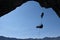 Silhouette of rock climbers over blue sky background