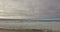 Silhouette rocky coastline looking from left to right on the beach. Stormy