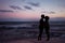 Silhouette romantic couple kissing at the ocean with colorfull sunset