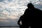 The silhouette of a romantic couple standing, hugging each other and watching the sunset. Romance and love concept