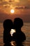 Silhouette Of Romantic Couple Standing In Sea