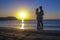 Silhouette of romantic lovers meeting sunrise sunset on the sea coast