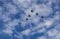 Silhouette of Royal Malaysian Air Force\\\'s Sukhoi Su-30MKM fly in formation across blue sky with thin clouds.