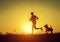 Silhouette of runner with dog in sunset rise