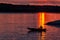 Silhouette of a sailor in a kayak canoe on the lake in the sunset light near an island, Danube River