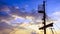 Silhouette of sails of an antique ship, masts and bowsprit of a schooner at a beautiful sunset, close up