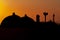 Silhouette of San Onofre nuclear power plant main reactors and alarm siren at sunset with sun visible