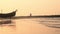 Silhouette sea beach soft water wave nature sunset with background of boat and defocused couple walking