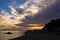 Silhouette of sea rocks and reflection of cloudscape at sunset