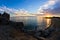 Silhouette of sea rocks and reflection of cloudscape at sunset