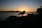 Silhouette of seagull on shore and fish rod during sunrise