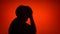 Silhouette of senior frustrated woman. Female`s face in profile in despair on red background