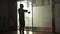 The silhouette of senior male lifting a barbell for biceps pumping up