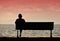 Silhouette of senior woman sitting alone on the bench