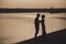 Silhouette of sensual embracing young happy couple celebrating their love on the beach. Toned image