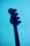 Silhouette or shadow of an electric bass guitar on a blue textured wall