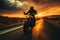 A silhouette shot of a motorcycle rider riding towards a captivating sunset.