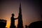 Silhouette shot of a person standing near Burj Khalifa hotel during sunset in Dubai, UAE