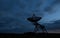 Silhouette shot of a radio telescope dish on a field during dusk