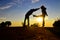 Silhouette Show the fight: Woman lift her leg and kick him to the tummy of a man at the mountain against the sunset