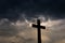 Silhouette of a simple catholic cross, dramatic stormclouds