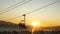 Silhouette skiers climbing up by the chair lift in sunrise