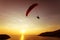 Silhouette of skydiver flies on background sunset sky and sea