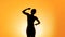 Silhouette of slim female practicing yoga at sunset, meditation and healthcare