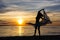 Silhouette of slim woman dancing with scarf on the beach