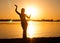 Silhouette of slim woman dancing tribal dance on beach