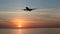 Silhouette of slow motion airplane flying in sunset