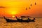 Silhouette Small fishing boat with birds and sunsets