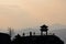 The silhouette of a small pavilion on the peak