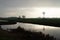 Silhouette of a small windmill in an agricultural setting used to drain the land in wetlands, the polder landscape in the