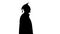 Silhouette Smiling male student in graduation robe walking with his diploma.