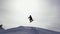 Silhouette of snowboarder jumping on mountain ski slope.