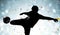 Silhouette soccer player kicking the ball