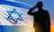 Silhouette of soldier saluting with Israel flag on background of sunrise or sunset. Armed forces of Israel concept