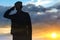 Silhouette of a solider saluting on a sunset