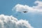 Silhouette sport aircraft with propeller and gliders, plane pulling a six against the blue sky in the air show performance.