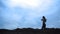 Silhouette sport girl walks on top of a hill