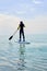 Silhouette sportsman stand up paddling on sup board or surfboard, enjoying sport