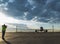 Silhouette of a spotter photographer with a camera and a telephoto lens, taking photos of an airliner