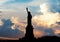 Silhouette of Statue of Liberty over dramatic full moon, New York, USA