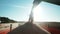 Silhouette of a steady stream of grains wheat funneled through a combine extension arm into truck container on sunny